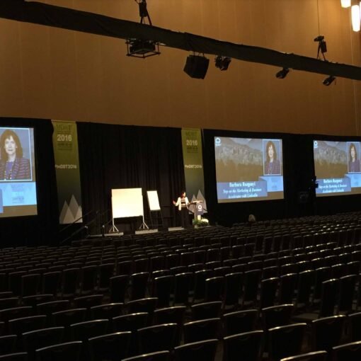 Barbara Rozgonyi delivering a keynote speech on LinkedIn strategy at the MDRT Annual Conference in Vancouver, speaking to a global audience in a 1,500-seat ballroom.