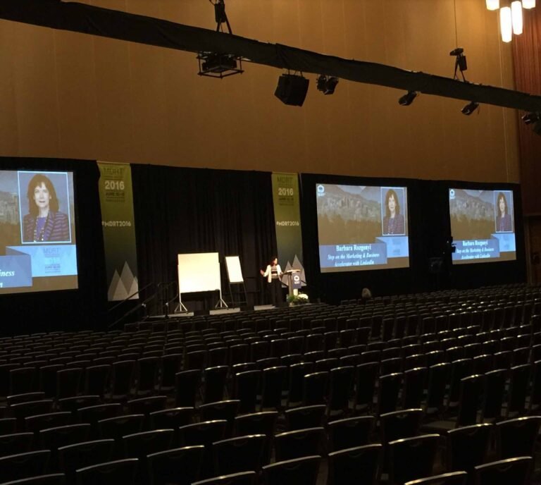 Barbara Rozgonyi delivering a keynote speech on LinkedIn strategy at the MDRT Annual Conference in Vancouver, speaking to a global audience in a 1,500-seat ballroom.